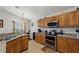 Bright kitchen with stainless steel appliances, oak cabinets, and tile flooring at 916 Balmoral Dr, Davenport, FL 33896