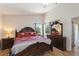 Cozy main bedroom with a queen bed, a dresser with a mirror, and hardwood floors at 916 Balmoral Dr, Davenport, FL 33896
