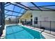 A view of the screened-in pool, outdoor seating, and a pool rules sign at 916 Balmoral Dr, Davenport, FL 33896