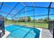Screened-in pool with clear blue water, a bright blue sky, and a view of the green backyard at 916 Balmoral Dr, Davenport, FL 33896