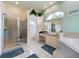 Bright bathroom featuring a light blue accent wall, walk in tub, and glass door shower at 7726 Ashford Dr, Lakeland, FL 33810