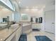 Bright bathroom featuring white cabinets, light blue accent wall, and walk in tub at 7726 Ashford Dr, Lakeland, FL 33810