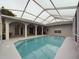Inviting pool with a screened-in enclosure, pillars, and an adjacent patio, blending indoor and outdoor living at 7726 Ashford Dr, Lakeland, FL 33810