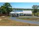 Charming home with a metal roof, circular driveway, and a view of the lake at 100 Masterpiece Rd, Lake Wales, FL 33898