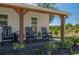 Cozy front porch with rocking chairs, wooden posts, and decorative plants creating a relaxing outdoor space at 100 Masterpiece Rd, Lake Wales, FL 33898