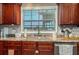 Kitchen sink with view window, granite countertops, and dark wood cabinets at 100 Masterpiece Rd, Lake Wales, FL 33898