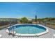 Above-ground pool with a deck and scenic views of the surrounding landscape and lake at 100 Masterpiece Rd, Lake Wales, FL 33898