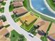 Aerial view of a home near a picturesque lake, showcasing beautiful landscaping and neighborhood charm at 1057 Sawgrass Dr, Winter Haven, FL 33884