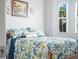 Bedroom featuring blue floral bedding, bright natural light, and a wooden bed frame create a cozy atmosphere at 1057 Sawgrass Dr, Winter Haven, FL 33884