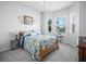 A bright bedroom with blue floral bedding, a ceiling fan, and large windows has a pleasant atmosphere at 1057 Sawgrass Dr, Winter Haven, FL 33884