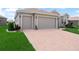 A spacious three-car garage with a brick paver driveway, providing ample parking and curb appeal at 1057 Sawgrass Dr, Winter Haven, FL 33884