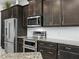 Modern kitchen showcasing stainless steel appliances, granite countertops, and dark cabinets at 1057 Sawgrass Dr, Winter Haven, FL 33884
