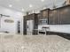 Spacious kitchen with stainless steel appliances, granite countertops, and dark wood cabinets offers plenty of storage at 1057 Sawgrass Dr, Winter Haven, FL 33884