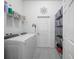 Clean laundry room with modern washer and dryer, plus shelving for storage at 1057 Sawgrass Dr, Winter Haven, FL 33884