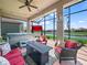 Covered patio with seating, a fire table, and a view of the lake at 1057 Sawgrass Dr, Winter Haven, FL 33884