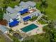Aerial view of a stunning property featuring a pool, patio, lush landscaping, and a charming two-story home at 125 E Graham Park Dr, Haines City, FL 33844