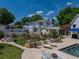 Beautiful backyard features a pool, lounge chairs, lush lawn, and mature trees at 125 E Graham Park Dr, Haines City, FL 33844