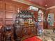 Elegant bar area featuring wood cabinetry, mirror accents, and marble floors at 125 E Graham Park Dr, Haines City, FL 33844