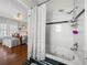 Bright bathroom featuring a soaking tub and shower with elegant white and black tile detail and hardwood flooring at 125 E Graham Park Dr, Haines City, FL 33844