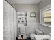 Traditional bathroom with paneled walls, shelving, and a patterned shower curtain at 125 E Graham Park Dr, Haines City, FL 33844