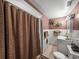 Bathroom showcasing a sink, toilet, floral wallpaper, and a shower with a brown shower curtain at 125 E Graham Park Dr, Haines City, FL 33844
