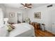 Comfortable bedroom with hardwood floors, ceiling fan, a trunk, and a chair at 125 E Graham Park Dr, Haines City, FL 33844