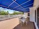 Elegant outdoor dining area on a spacious deck with a blue awning and charming white railings at 125 E Graham Park Dr, Haines City, FL 33844