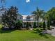Expansive two-story home boasts lush landscaping, a metal roof, and a welcoming front porch at 125 E Graham Park Dr, Haines City, FL 33844