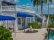 Exterior showcasing backyard with patios, gardens, and blue awnings enhancing this white home by the lake at 125 E Graham Park Dr, Haines City, FL 33844