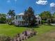 Charming exterior view showcasing lush landscaping, a spacious yard, and a beautiful home with a wrap-around porch at 125 E Graham Park Dr, Haines City, FL 33844