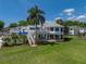 Stunning two-story home with a metal roof, surrounded by a well-manicured lawn and lush tropical landscaping at 125 E Graham Park Dr, Haines City, FL 33844