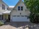 Charming home exterior showcasing a wide garage door, lush landscaping, and a welcoming front entrance at 125 E Graham Park Dr, Haines City, FL 33844