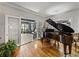 Sunlit music room with grand piano and a view to a relaxing lounge area through french doors at 125 E Graham Park Dr, Haines City, FL 33844