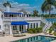 Inviting pool area with lounge chairs, lush landscaping, and a charming home with awnings in the background at 125 E Graham Park Dr, Haines City, FL 33844