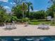 Charming backyard featuring an inground pool, white patio furniture, and a beautiful garden at 125 E Graham Park Dr, Haines City, FL 33844