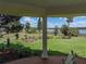 Picturesque view from the porch overlooking a lush green lawn and serene waterfront, showcasing beautiful landscaping at 125 E Graham Park Dr, Haines City, FL 33844