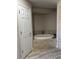 Bathroom featuring a luxurious soaking tub with marble tile surround at 1403 Hidden Creek Ln, Winter Haven, FL 33880