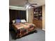 Cozy bedroom with a ceiling fan, a quilt-covered bed, and built-in shelving at 1403 Hidden Creek Ln, Winter Haven, FL 33880