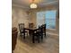 Well-lit dining room with a black table, wooden chairs, and light fixture at 1403 Hidden Creek Ln, Winter Haven, FL 33880