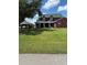 Charming two-story brick home with a spacious, well-manicured front lawn and covered porch at 1403 Hidden Creek Ln, Winter Haven, FL 33880