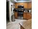 Functional kitchen featuring stainless steel appliances, wooden cabinets, and granite countertops at 1403 Hidden Creek Ln, Winter Haven, FL 33880