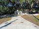 House with concrete driveway and well-manicured lawn, nestled under the shade of mature trees at 180 Old Connersville Rd, Bartow, FL 33830