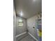 Functional laundry room featuring gray walls, window, and modern gray wood-look flooring at 180 Old Connersville Rd, Bartow, FL 33830