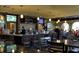 Enjoy refreshments at the stylish bar featuring dark wood accents, pendant lighting, and multiple television screens at 1942 Bermuda Pointe Dr, Haines City, FL 33844