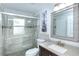 Well-lit bathroom with decorative framed mirror, a large glass-enclosed shower, and decorative gray wall tile at 1942 Bermuda Pointe Dr, Haines City, FL 33844