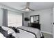 Well-lit bedroom with gray walls, wood-look tile floors, ceiling fan, and a dark wood dresser at 1942 Bermuda Pointe Dr, Haines City, FL 33844