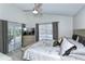 A well-lit bedroom with cool tones, featuring a sliding glass door, and large window overlooking the backyard at 1942 Bermuda Pointe Dr, Haines City, FL 33844