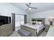 Beautiful bedroom featuring wood-look tile floors, gray walls, and a stylish ceiling fan with attached light fixture at 1942 Bermuda Pointe Dr, Haines City, FL 33844