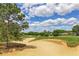 Scenic view of the golf course with beautiful trees, well-maintained greens, and a sand trap at 1942 Bermuda Pointe Dr, Haines City, FL 33844