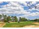 Picturesque view of the golf course with golf carts on the fairway surrounded by lush trees at 1942 Bermuda Pointe Dr, Haines City, FL 33844
